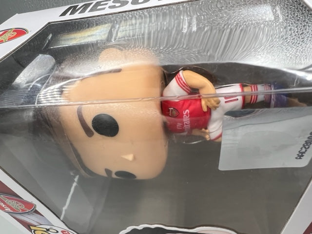 A boxed collectible figure of soccer player Lionel Messi in a red and white Argentina jersey, visible through a clear plastic window in the packaging.
